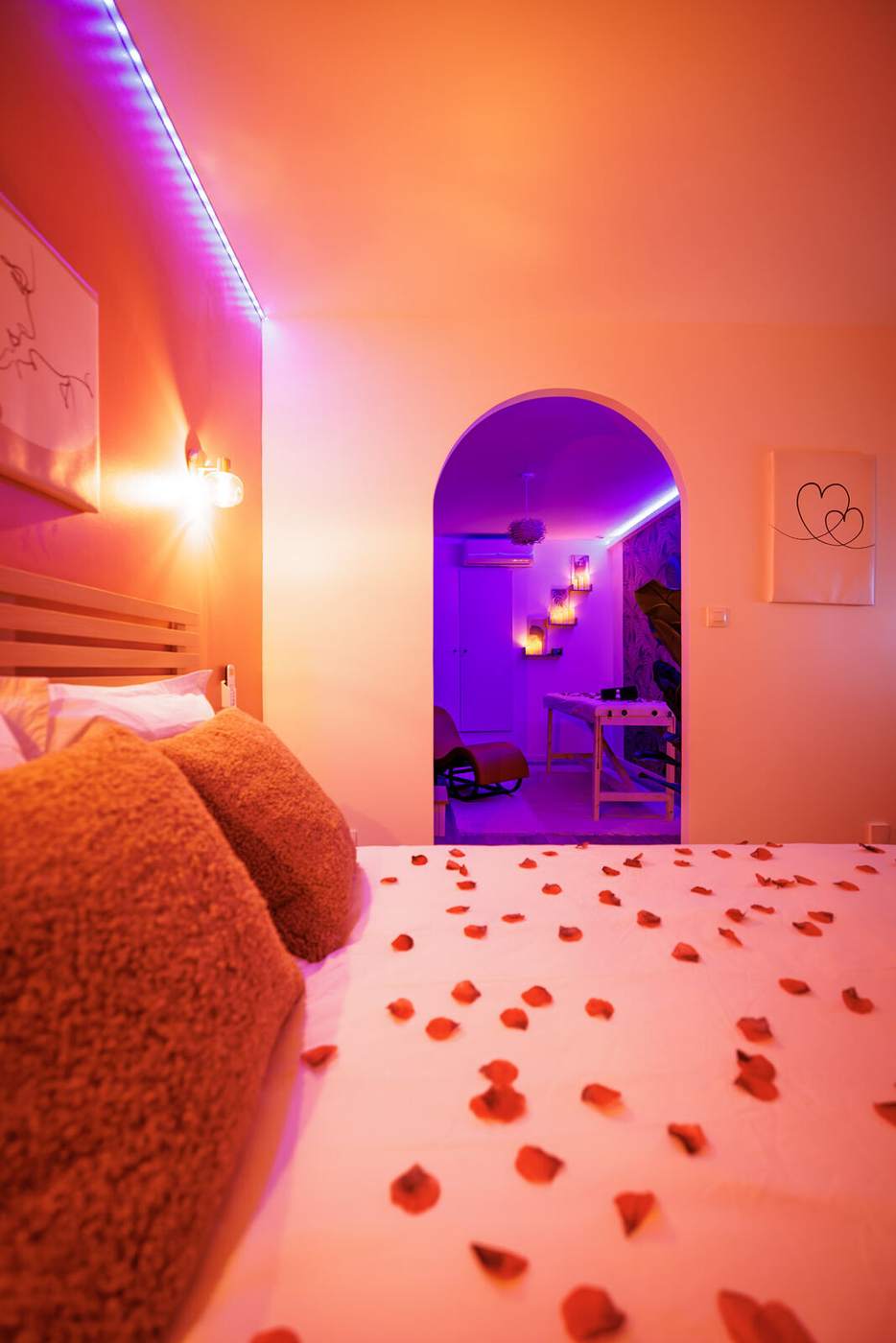 Chambre de la love room à Vienne avec pétales de rose et alcôve éclairée